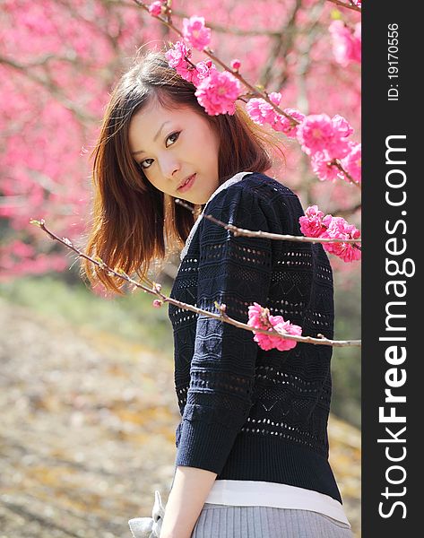 Young japanese woman outdoors by blossoms tree