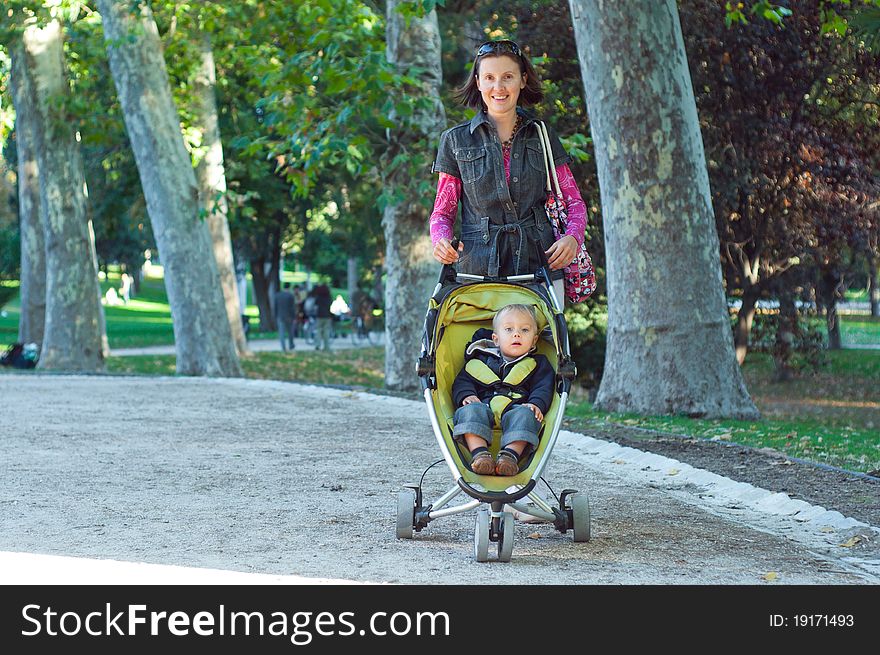 Happy mother with her son walking in the park in the sunny day