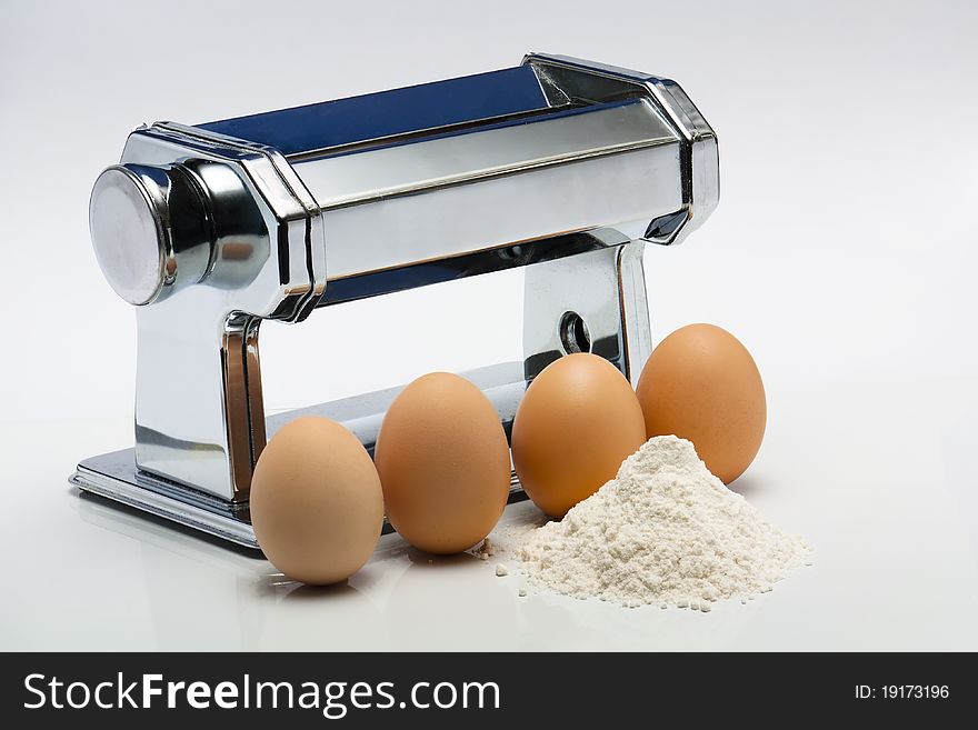 Pasta machine with eggs and flour ingredients for making pasta