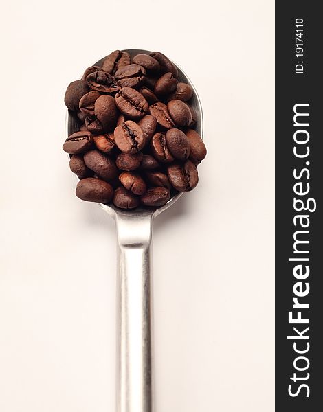 A spoon full of coffee beans. A spoon full of coffee beans.