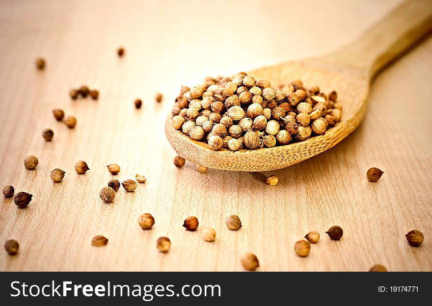 Coriander seeds wooden spoon on a wooden surface. Coriander seeds wooden spoon on a wooden surface.