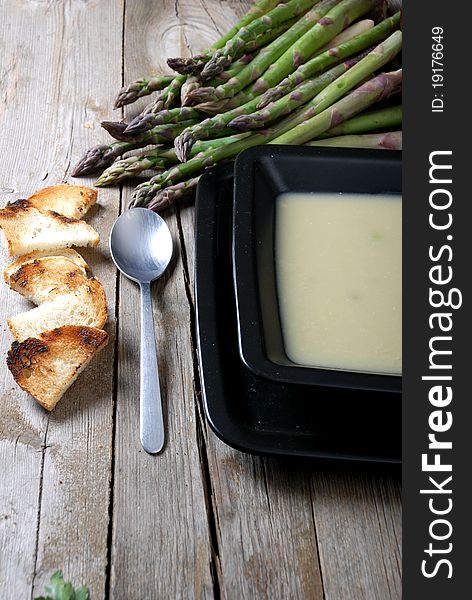 Close up of asparagus soup and black flat piece of wood photographed in gallarate