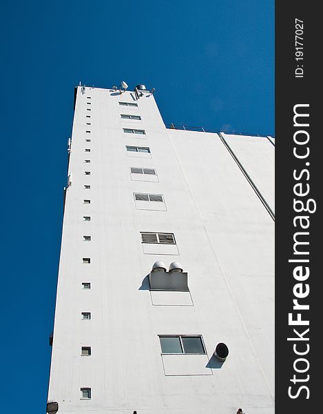 Big white harbor building with small windows climbing to the sky