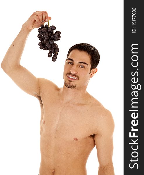 A man is holding up some grapes ready to eat them. A man is holding up some grapes ready to eat them.