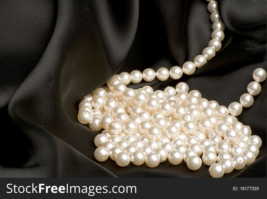 White pearls on a black satin fabric