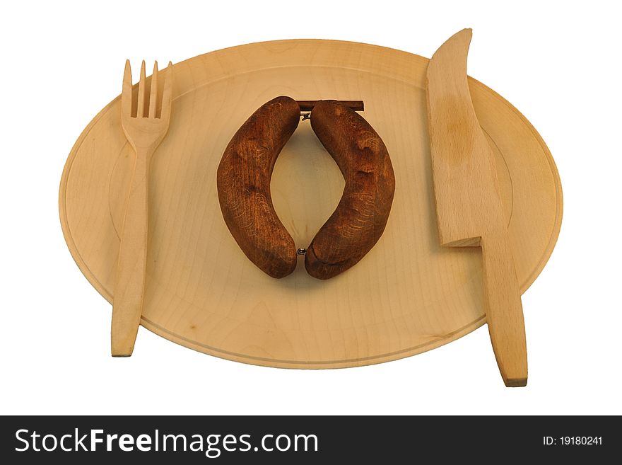 Wooden sausages on wooden plate with wooden fork and knife isolated on white background. Wooden sausages on wooden plate with wooden fork and knife isolated on white background.