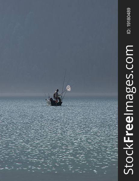 Fishermen on the lake on a misty morning. Fishermen on the lake on a misty morning