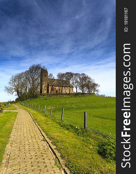 Path to an old church on a high hill surrounded with trees