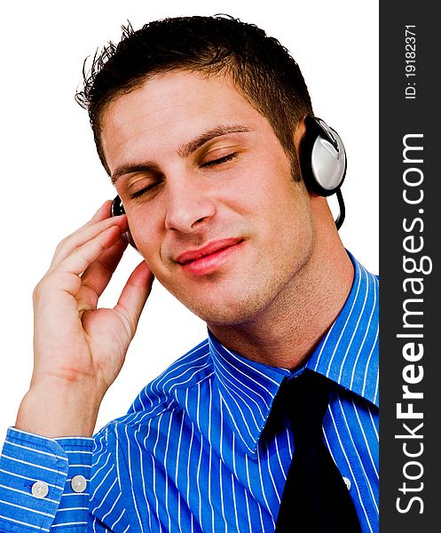 Man listening to music on a headphones and smiling isolated over white. Man listening to music on a headphones and smiling isolated over white