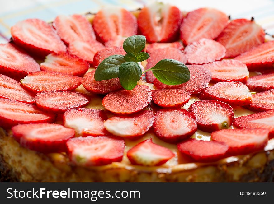 Top of a delicious strawberry vanilla cheesecake with mint. Top of a delicious strawberry vanilla cheesecake with mint.