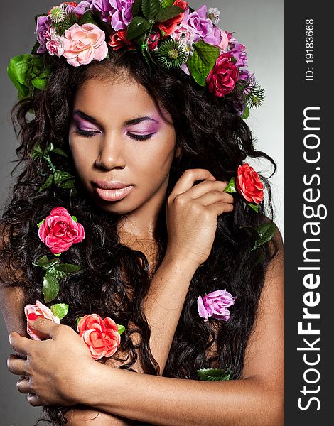 Elegant mulatto girl with circlet of flowers