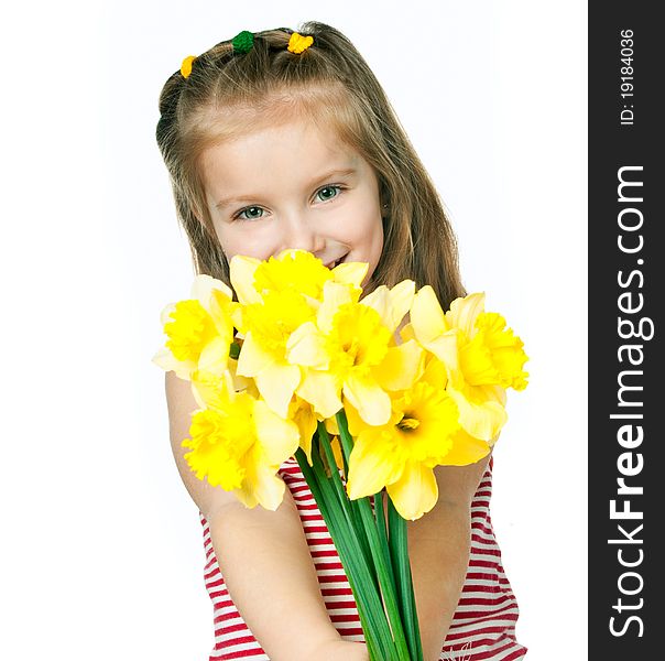 Beautiful little girl with a bouquet of daffodils