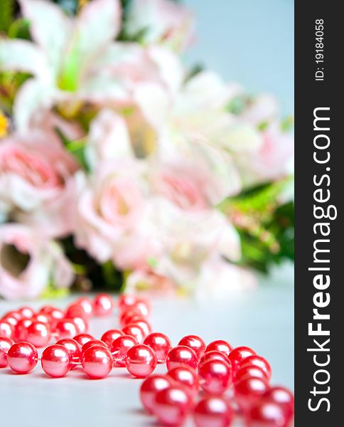 Red beads on a background of a bouquet of flowers