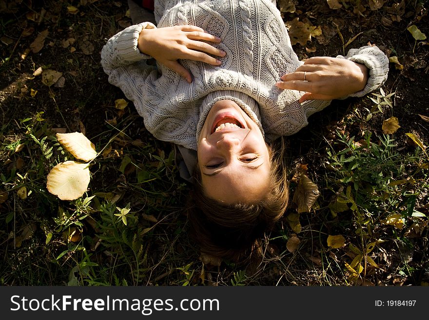 Girl is smiling and laying on the ground. Girl is laughing. Girl is smiling and laying on the ground. Girl is laughing.