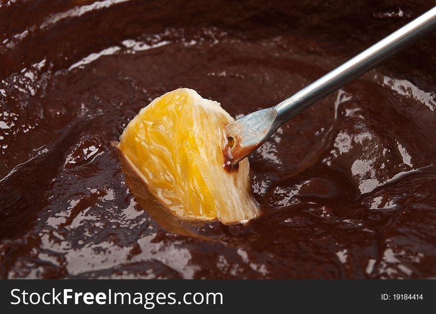 Delicious chocolate fondue with orange macro background