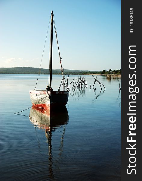 A fisherman's sail boat or dhow moored at a lagoon in Mozambique. A fisherman's sail boat or dhow moored at a lagoon in Mozambique