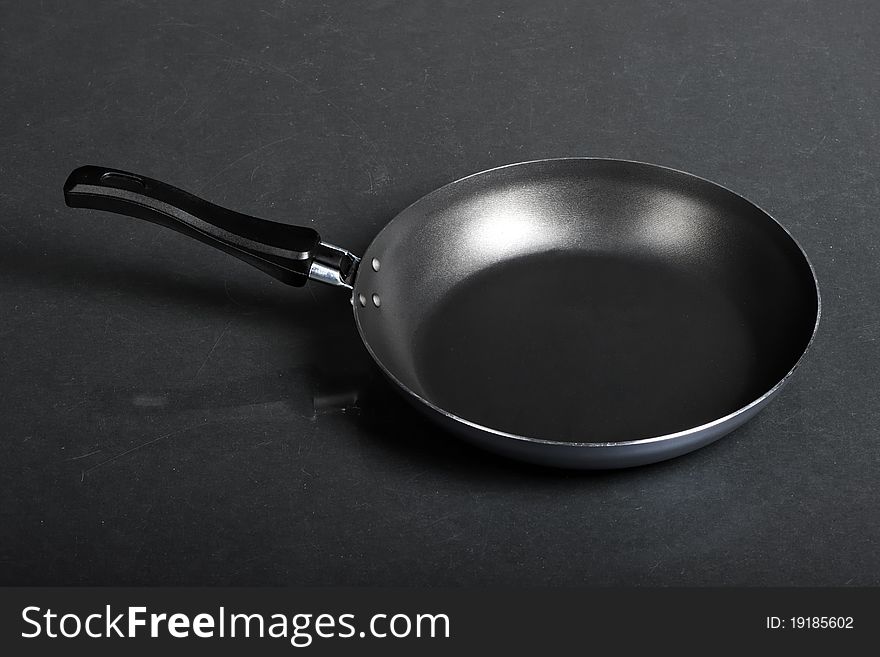 Frying pan on black background