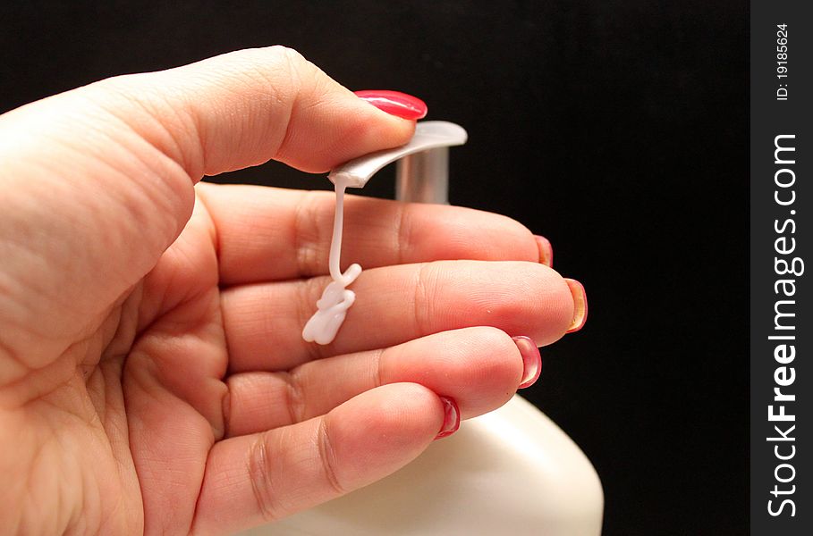 A woman's hand shown pumping lotion from a bottle. A woman's hand shown pumping lotion from a bottle