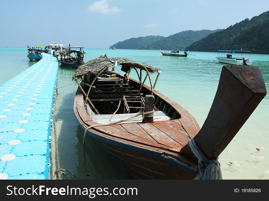 A Thai tradition wood long tail boat park by the jetty. A Thai tradition wood long tail boat park by the jetty.