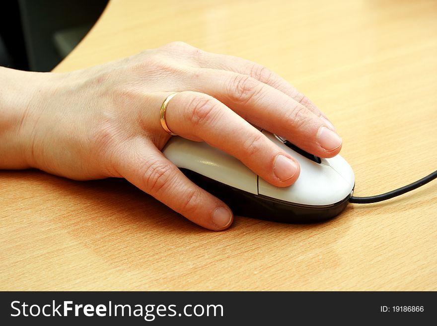 Computer mouse with hand on the table