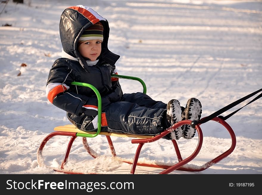 Boy smiling happy having a good time sledding. Boy smiling happy having a good time sledding