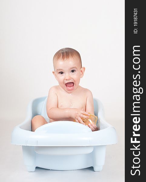 9 month old baby boy taking a bath exibiting happiness and fun. 9 month old baby boy taking a bath exibiting happiness and fun.