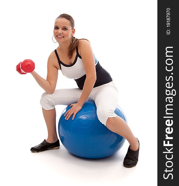 Lovely smiling woman is working out on a blue fitness ball. Lovely smiling woman is working out on a blue fitness ball