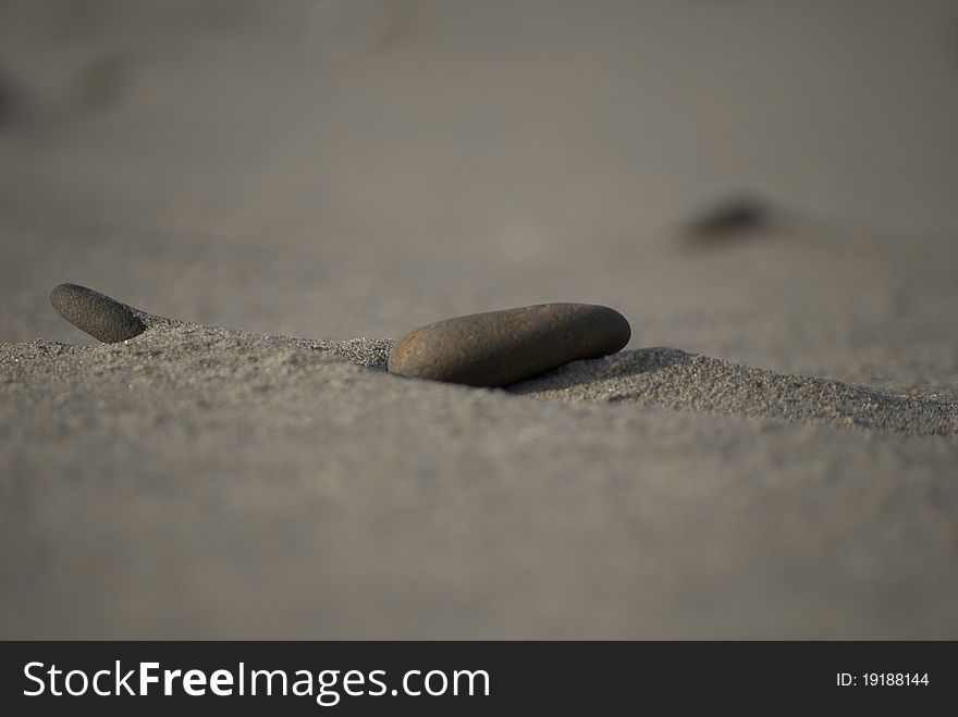 Small river rock in the sand, depth of field photo. Small river rock in the sand, depth of field photo