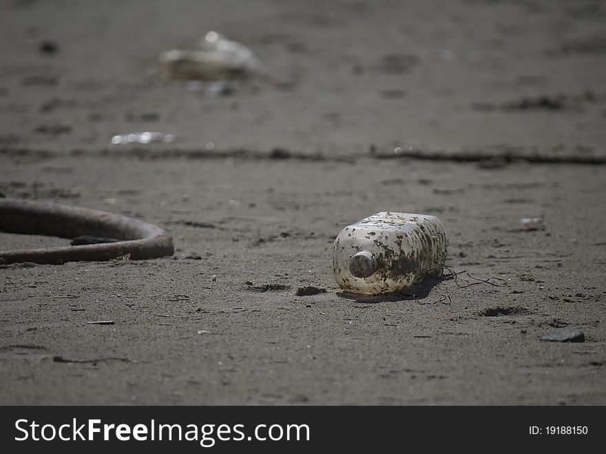 Empty bottle littered on the beach. Empty bottle littered on the beach