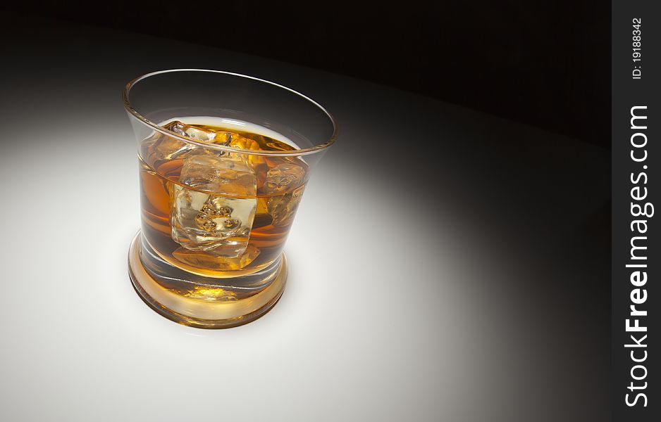 Glass of Whiskey or Other Alcoholic Drink and Ice Under Spot Light. Glass of Whiskey or Other Alcoholic Drink and Ice Under Spot Light.