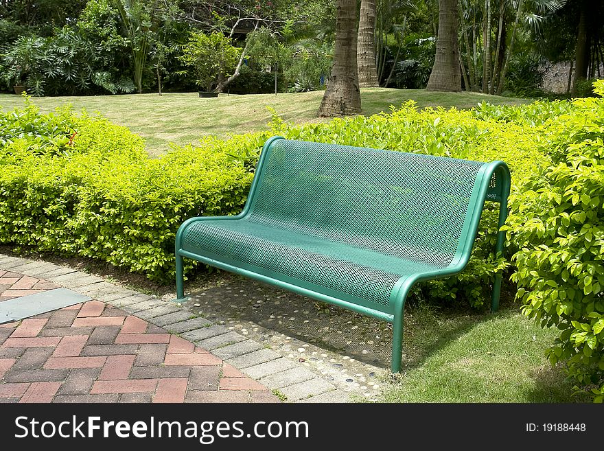 A modern metallic bench in peaceful garden of park. A modern metallic bench in peaceful garden of park