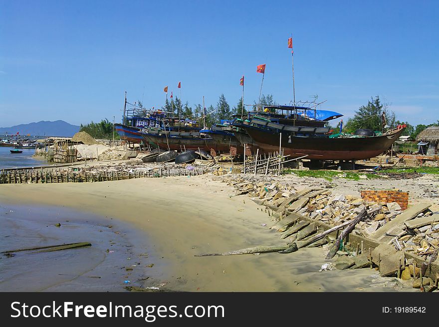 Fishing boat Lamparo at anchor. All boats are identical in the Vietnamese fishing fleet. They are made of wood painted blue with a reminder of the country's symbol is the dragon. In his bow with a red dot for fire and on the flat edge of the eye of the dragon . The red flag with yellow star is always at the end of the bamboo pole. Fishing boat Lamparo at anchor. All boats are identical in the Vietnamese fishing fleet. They are made of wood painted blue with a reminder of the country's symbol is the dragon. In his bow with a red dot for fire and on the flat edge of the eye of the dragon . The red flag with yellow star is always at the end of the bamboo pole.