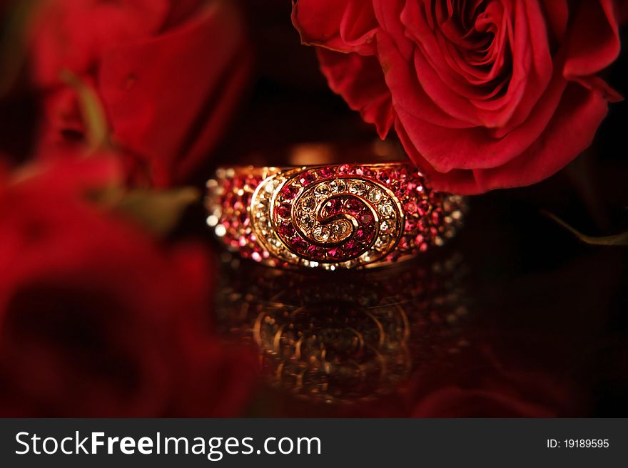 Ring with diamonds & red roses on the bacground