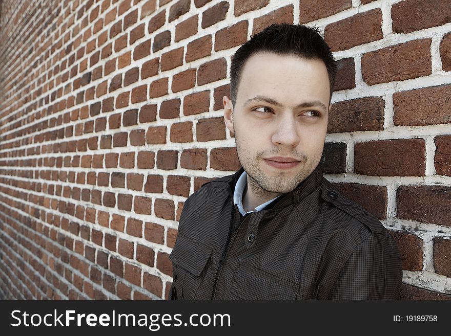 Young Man In Fron Of The Brick Wall