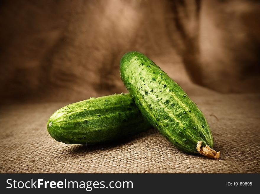 Two fresh cucumbers on the brown sacking background. Two fresh cucumbers on the brown sacking background