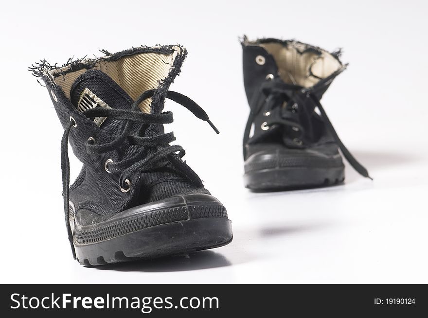 Used unisex black boots on white surface