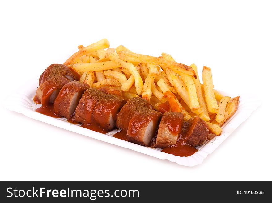 A bowl with curried sausage and chips in front of white background