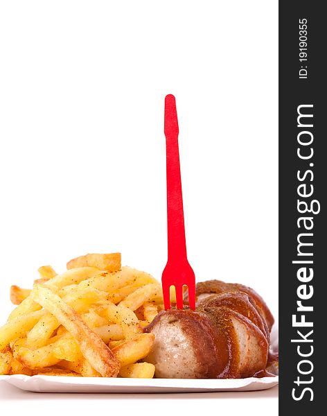 A bowl with curried sausage and chips in front of white background