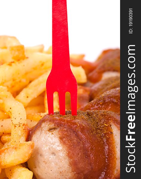 Curried sausage with chips and a red fork. Curried sausage with chips and a red fork