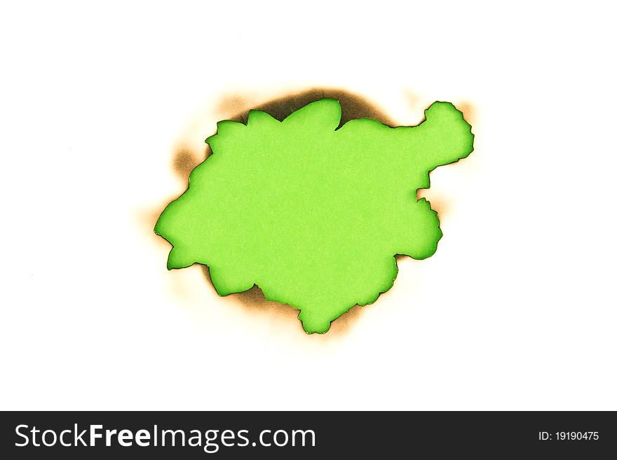 Burnt hole in a paper over green paper background