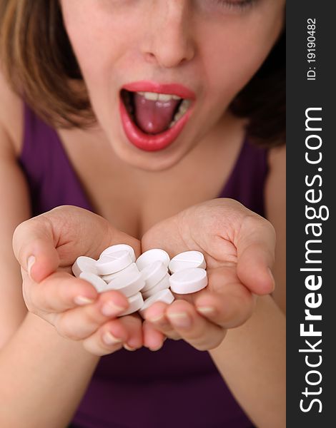 Close-up of a young woman holding many white pills in her hands. Shallow depth of field, focus on pills. Close-up of a young woman holding many white pills in her hands. Shallow depth of field, focus on pills.