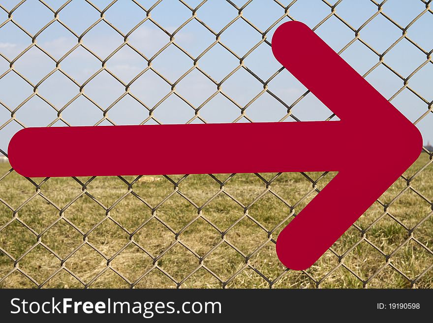 Directional arrow fastened to a fence. Directional arrow fastened to a fence.