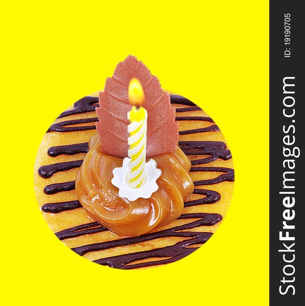 Cake with yellow candle isolated on yellow surface. Cake with yellow candle isolated on yellow surface.