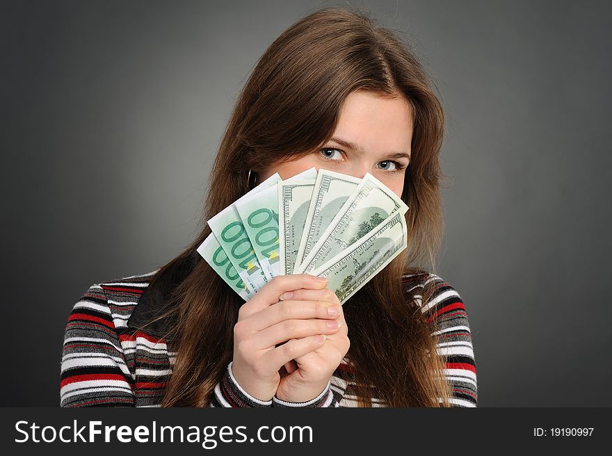 Pretty woman smiling while holding fan made of money. Pretty woman smiling while holding fan made of money