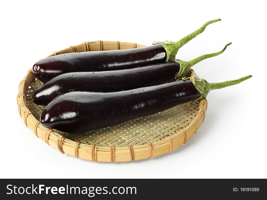 Some eggplants in basket isolated on white background