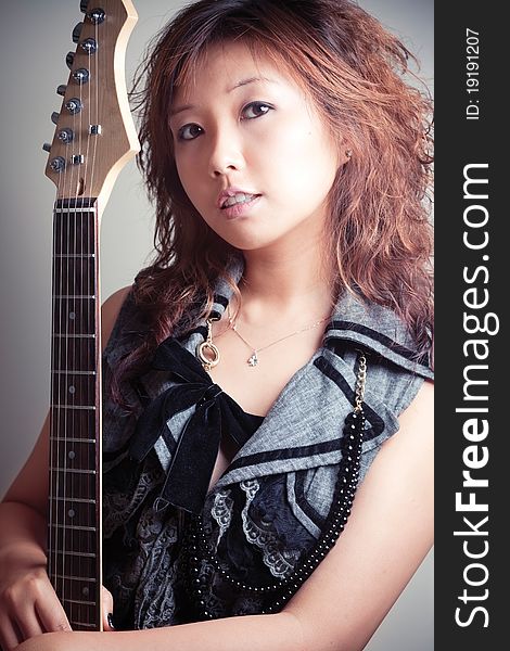 Young asian woman with a red guitar. Young asian woman with a red guitar.