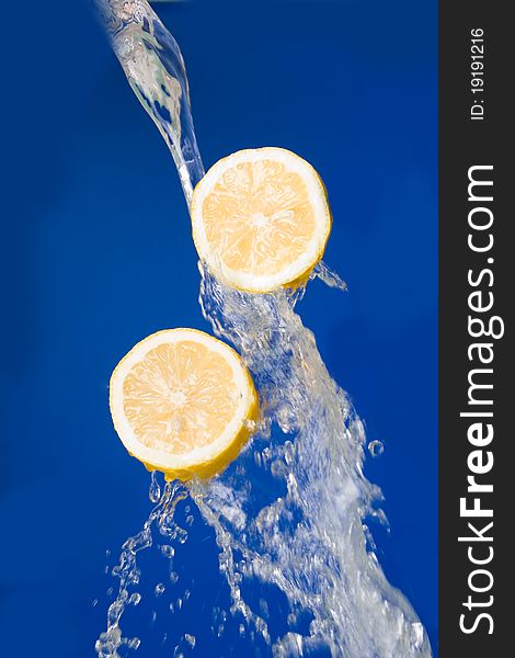 Two halves of lemon in the splashes of water