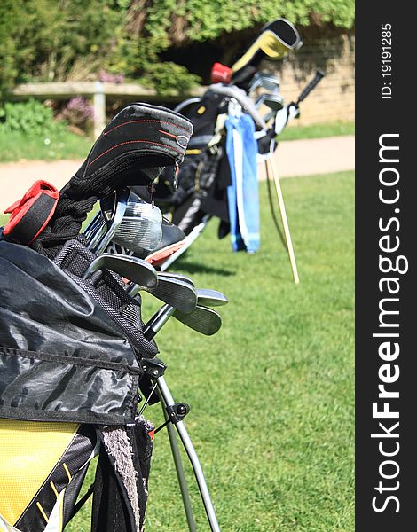 Image of a golf bags standing on the green taken in bright sun light