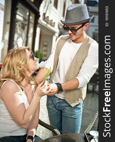 Young man gives a flower to his girlfriend. Young man gives a flower to his girlfriend