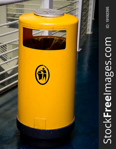 Yellow garbage bin in public. Yellow garbage bin in public